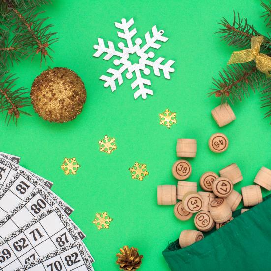 Bankoplader og bankobrikker på grøn baggrund. Rundt om ligger snefnug, julekugler og gran.